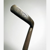 Back of the J. Gourlay putter blade showing both oval maker stamps and the offset hosel, hickory golf