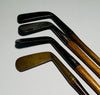 Four-piece gutty-era hickory golf play set with three smooth-face irons and a brass putter on a white background