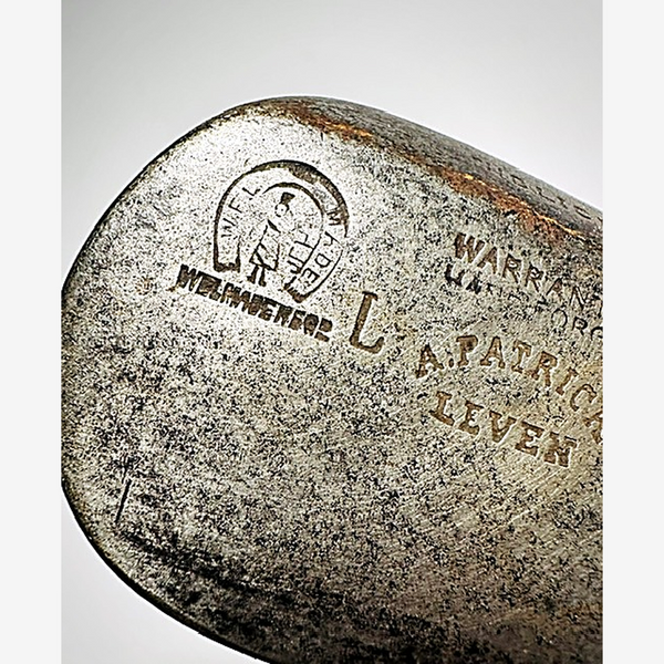 Close-up of the A. Patrick Leven maker stamp and horseshoe mark on the hickory golf niblick head