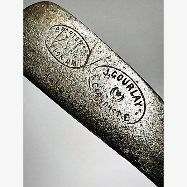 Close-up of the J. Gourlay Carnoustie cleek mark and Sportsman's Emporium retailer stamp on the hickory golf putter
