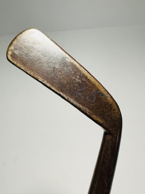 Smooth-face cleek head close-up showing period patina and faint number stamp