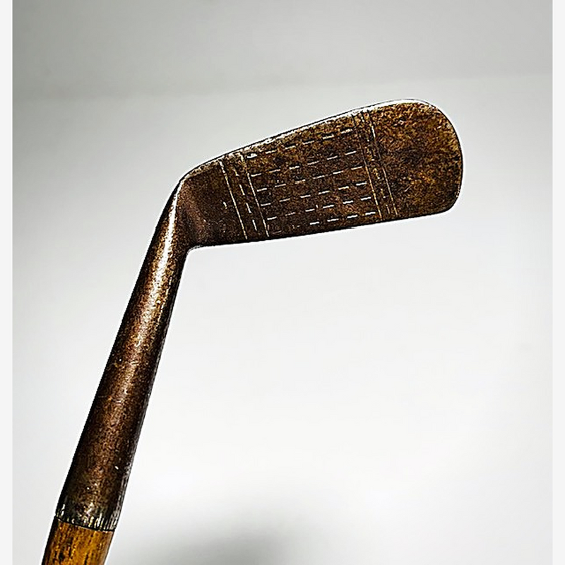Cross-hatch scored face of the W. Gibson hickory golf jigger at address